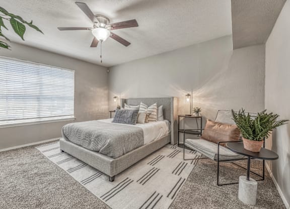 Cozy bedroom with neutral decor and ceiling fan at Northwood Heights Apartments, Dallas, 75248