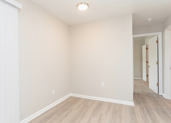 an empty living room with white walls and wood flooring