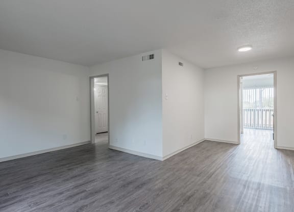an empty living room with white walls and wood flooring