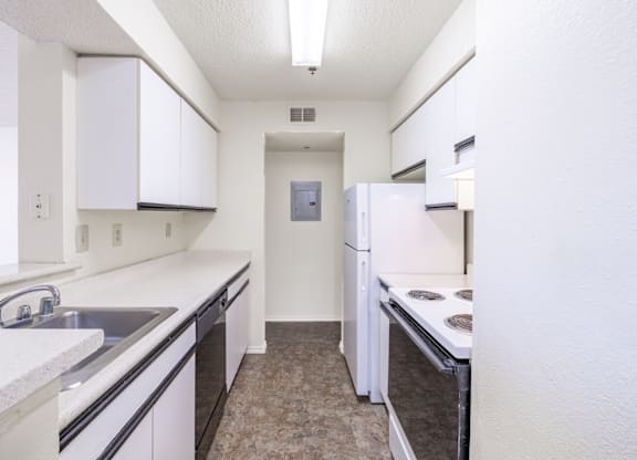 A kitchen with white cabinets and appliances.