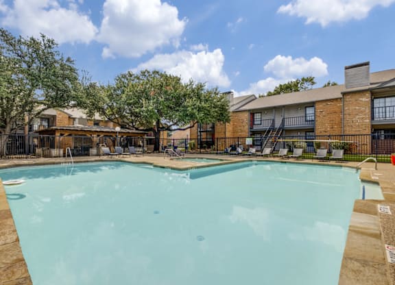 A large swimming pool in front of a brick building.