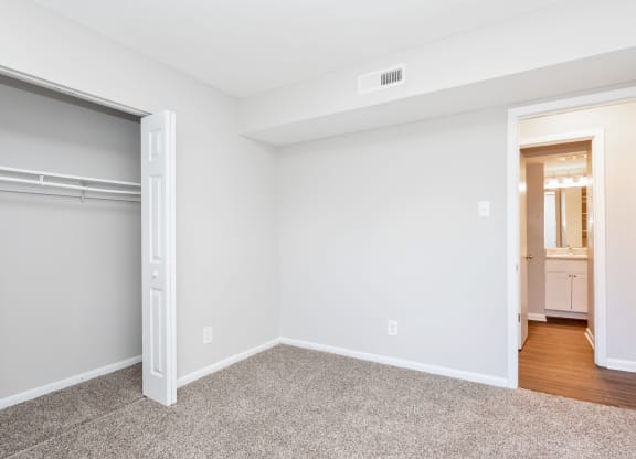 a bedroom with a closet and a door to a bathroom