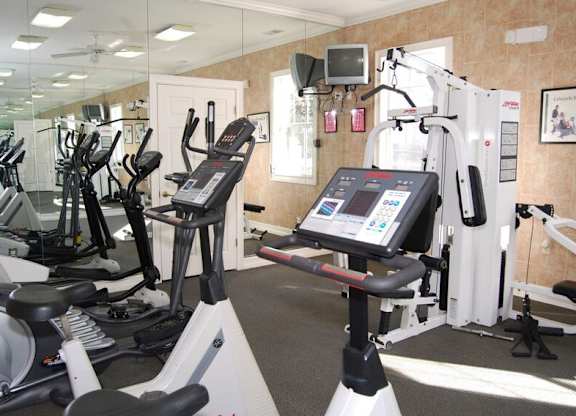 A gym with treadmills, elliptical machines, and other exercise equipment.