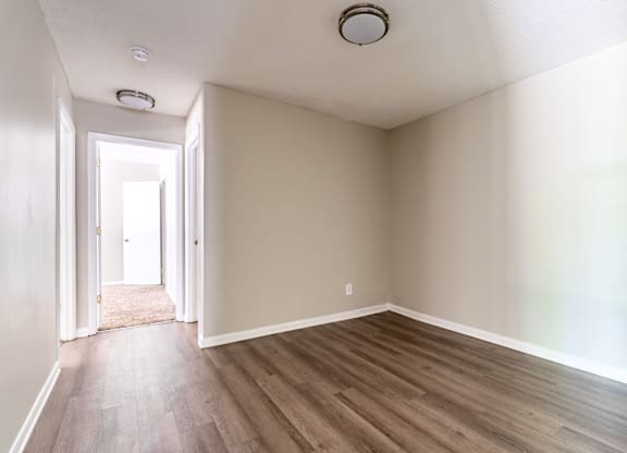 A room with wooden flooring and a white door.