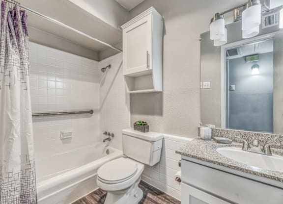 Renovated bathroom with white subway tile at Northwood Heights Apartments, Texas, 75248