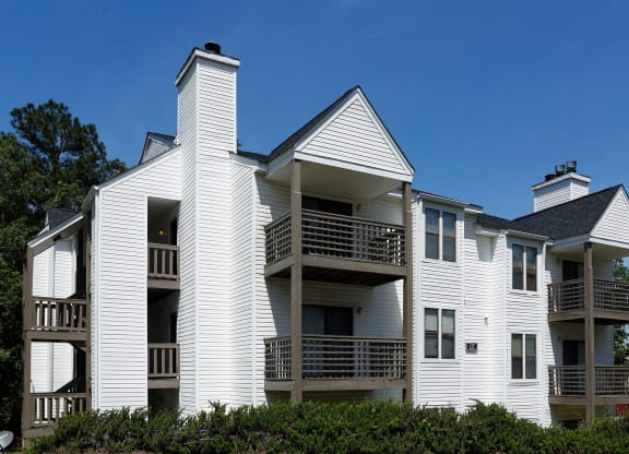 an apartment building with white siding and balconies