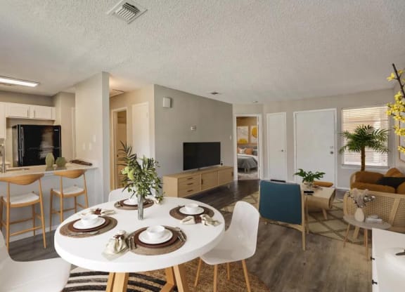a living room and dining room with a table and chairs