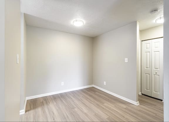 A room with a wooden floor and a white door.