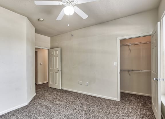 A bedroom with a closet and a ceiling fan in Arlington, TX.