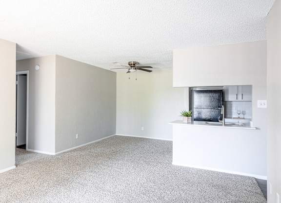 A spacious living room with a ceiling fan and a small kitchenette. at Leander, Texas