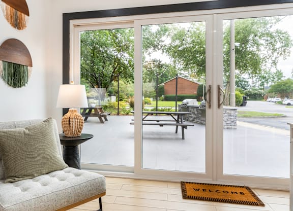 A welcoming interior with a view of a park through the glass doors.