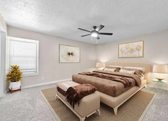 A bedroom with a large bed and a ceiling fan.