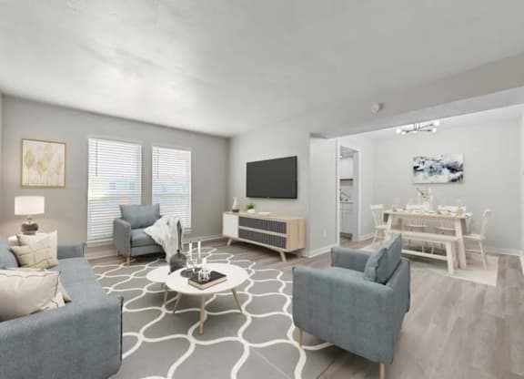 A living room with a grey couch, a white coffee table, and a television.