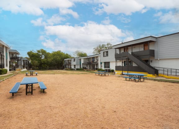 Community area with picnic tables and benches at Carisma, Dallas, 75240