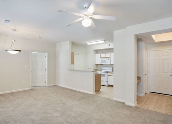 A spacious room with a ceiling fan and a kitchen area in the background in Arlington, TX.