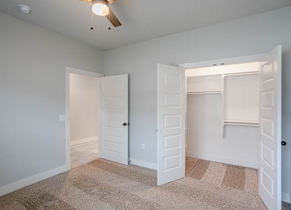 A room with two white doors and a carpeted floor at Cedar Crest Apartments, Farmington, AR, 72730