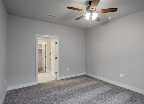 A room with a ceiling fan and a carpeted floor at Cedar Crest Apartments, Farmington, Arkansas