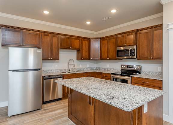 A kitchen with wooden cabinets and granite countertops at Cedar Crest Apartments, Arkansas, 72730