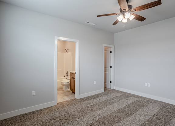 A room with a ceiling fan and a carpeted floor at Cedar Crest Apartments, Farmington, AR