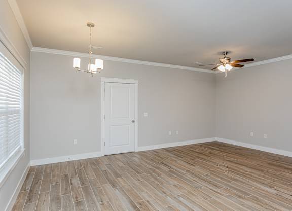 A room with a ceiling fan and a door at Cedar Crest Apartments, Farmington, AR