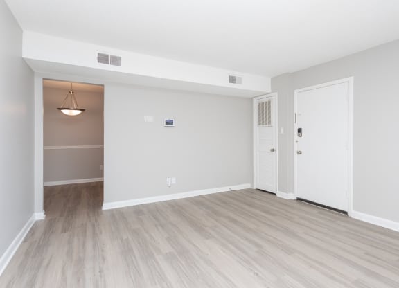 an empty living room with white walls and wood flooring
