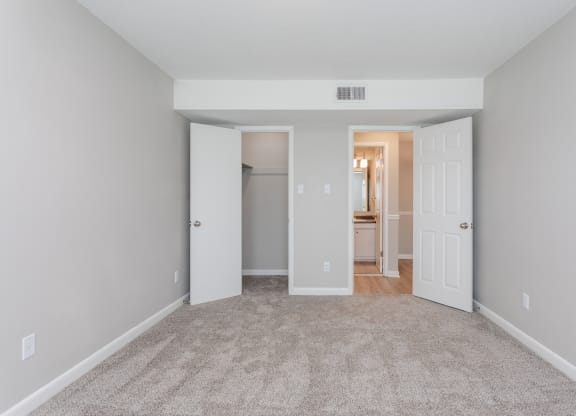 a living room with carpet and a door to a bathroom