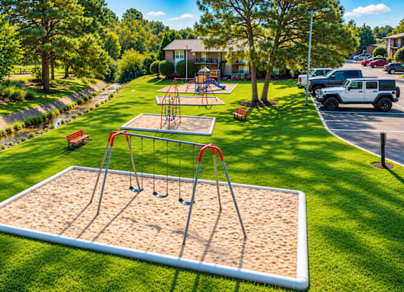 A playground with a swing set and sandbox in the foreground.