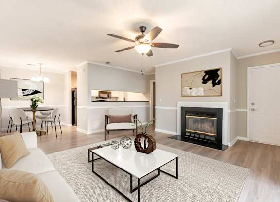 A living room with a fireplace and a white couch. at Rosewood at Colony Square, Rocky Mount