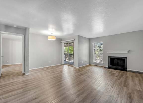 A spacious living room with a fireplace and sliding glass doors.