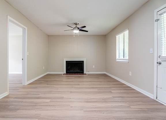 A room with a fireplace and a ceiling fan. at Rosen at North Hills, Raleigh, NC, 27609