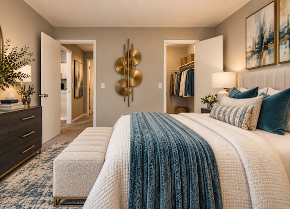 A bedroom with a large bed and a dresser with a plant on top.