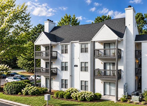 A white two story apartment building with balconies.