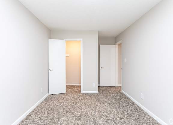 an empty room with white walls and doors