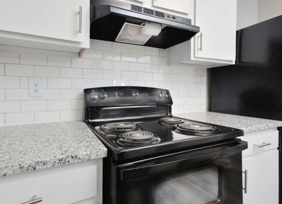 a kitchen with white cabinets and a black stove  at Henley, North Carolina, 28311