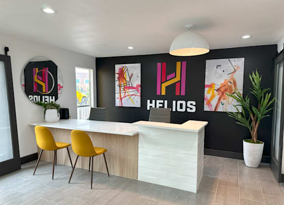 a modern reception area with yellow chairs and a white reception desk