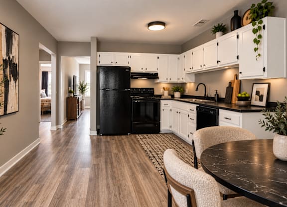 A modern kitchen with a black stove top oven and white cabinets.
