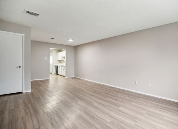 the living room and dining room of an apartment with wood flooring