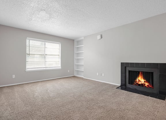 an empty living room with a fireplace and a window