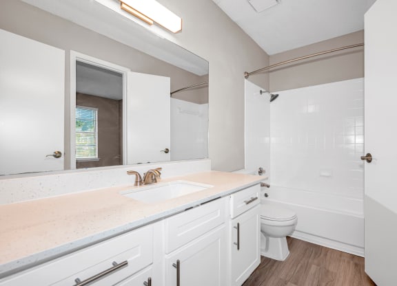 a bathroom with white cabinets and a sink and a toilet