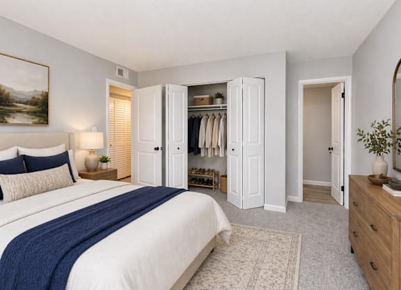 A bedroom with a large bed, a dresser, and a mirror.