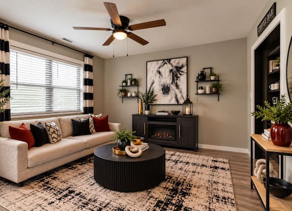 A living room with a white couch, a black coffee table, and a ceiling fan.