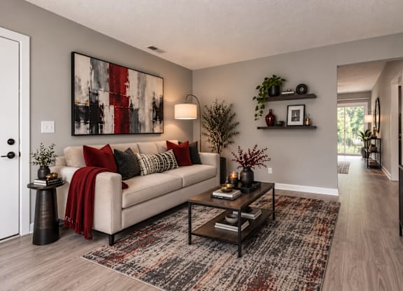A living room with a couch, a coffee table, and a large painting on the wall.