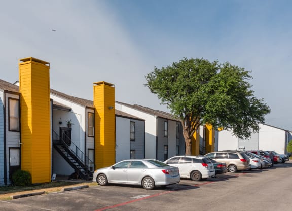 a row of houses with cars parked in front of them at Helios, Dallas, TX 75240