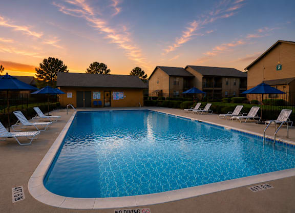 Outdoor pool with lounge seating at dusk at Ridgeview Apartments, Texas