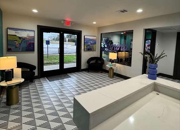 A black and white tiled lobby with a white reception desk.