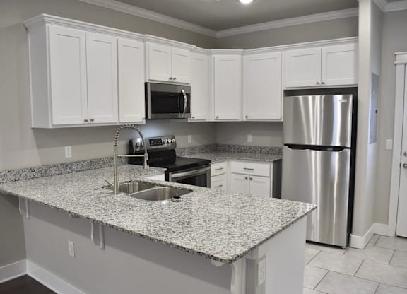 A kitchen with granite countertops and stainless steel appliances at Cedar Crest Apartments, Arkansas, 72730