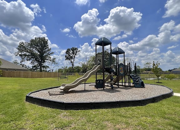 A playground with a slide and a green tower at Cedar Crest Apartments, Farmington 72730