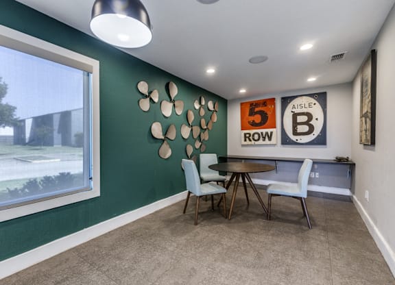 A living room with a green wall and a table with two chairs.