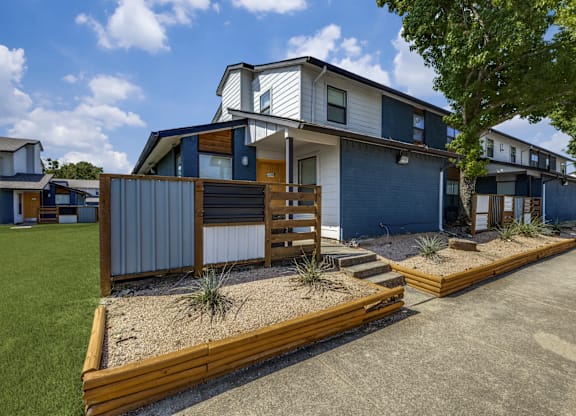 A modern house with a blue exterior and a wooden deck.