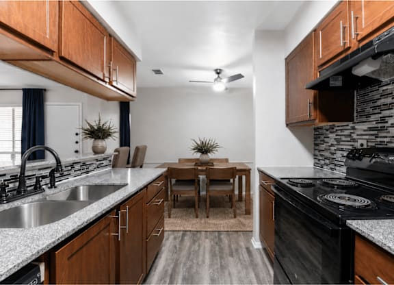 Galley kitchen with granite countertops and mosaic backsplash at Ridgeview Apartments, Sherman, TX 75092